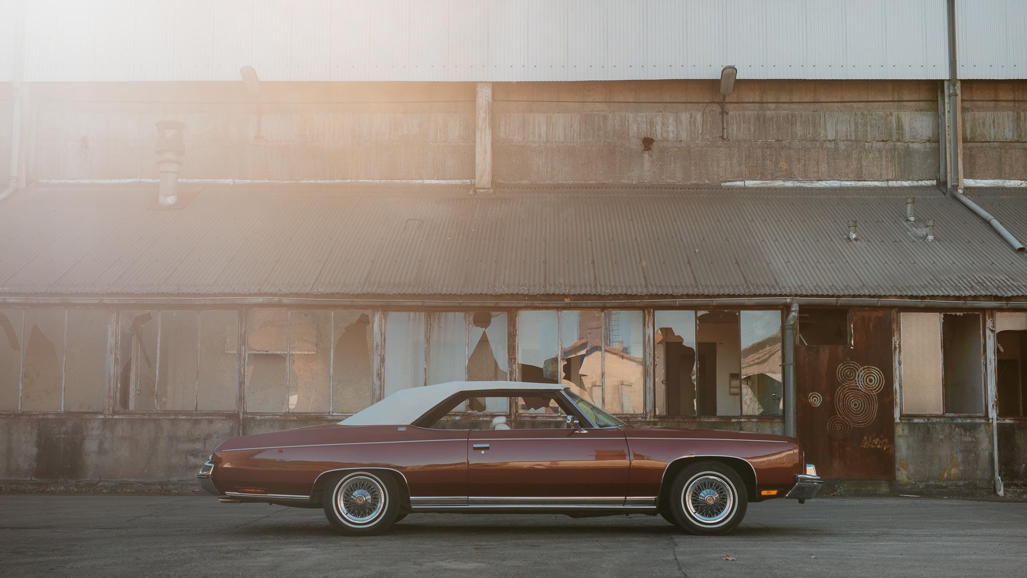 Séance couple après mariage mise en scène avec voiture américaine de collection dans une friche industrielle aux alentours de Nantes par Geoffrey Arnoldy photographe