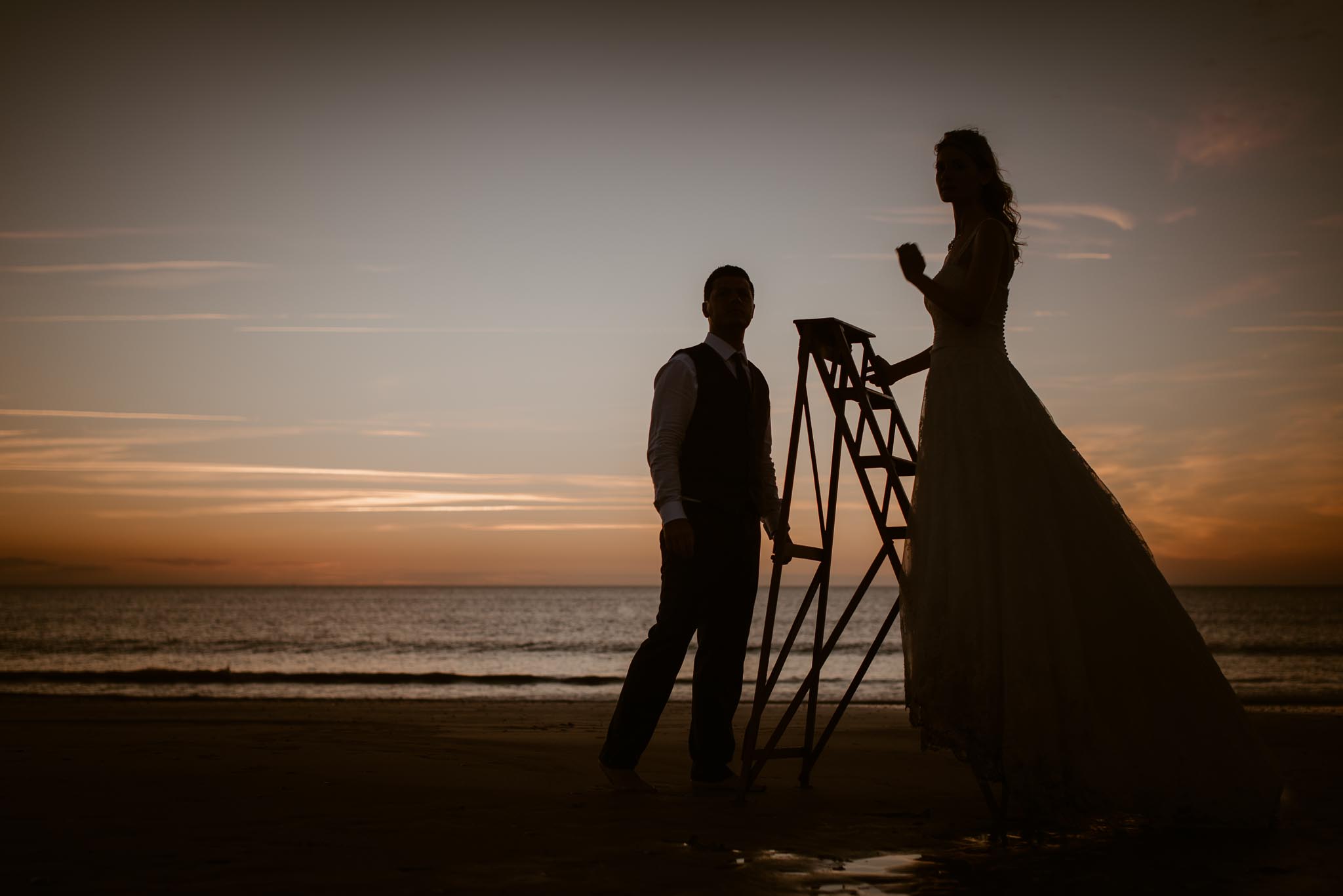 Séance couple après mariage mise en scène poétique et romantique sur la plage à Pornic au coucher de soleil par Geoffrey Arnoldy photographe