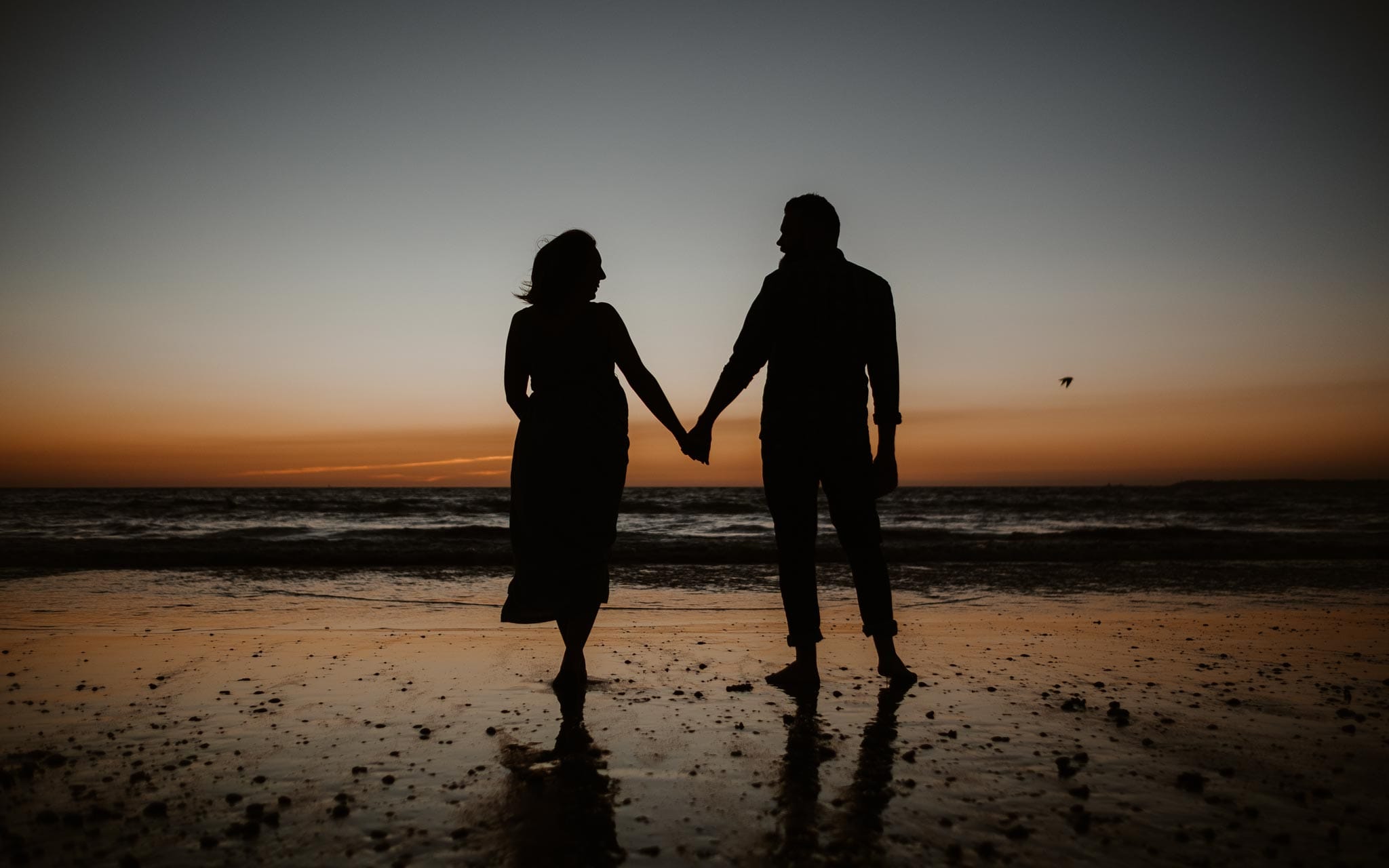 Séance couple femme enceinte en extérieur, à l’ambiance poétique et romantique, au coucher de soleil sur la plage à la Baule par Geoffrey Arnoldy photographe