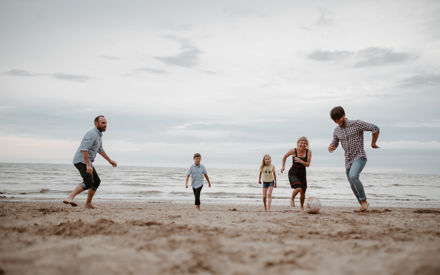 Séance photo de famille parents enfant en extérieur jouant de la musique autour d’un feu en été à Pornic par Geoffrey Arnoldy photographe