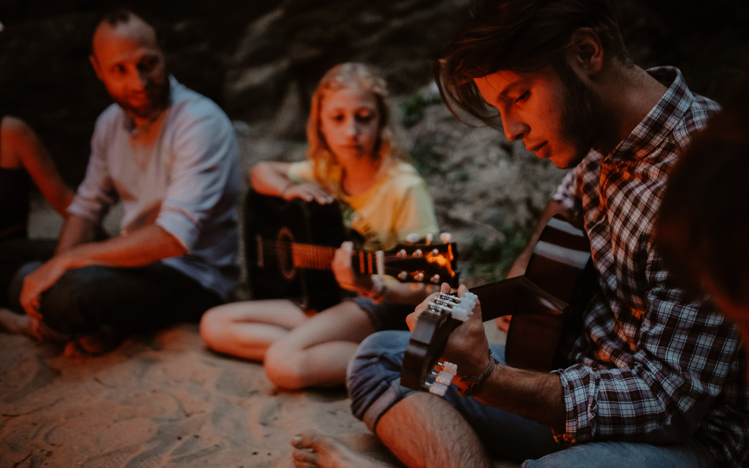 Séance photo de famille parents enfant en extérieur jouant de la musique autour d’un feu en été à Pornic par Geoffrey Arnoldy photographe