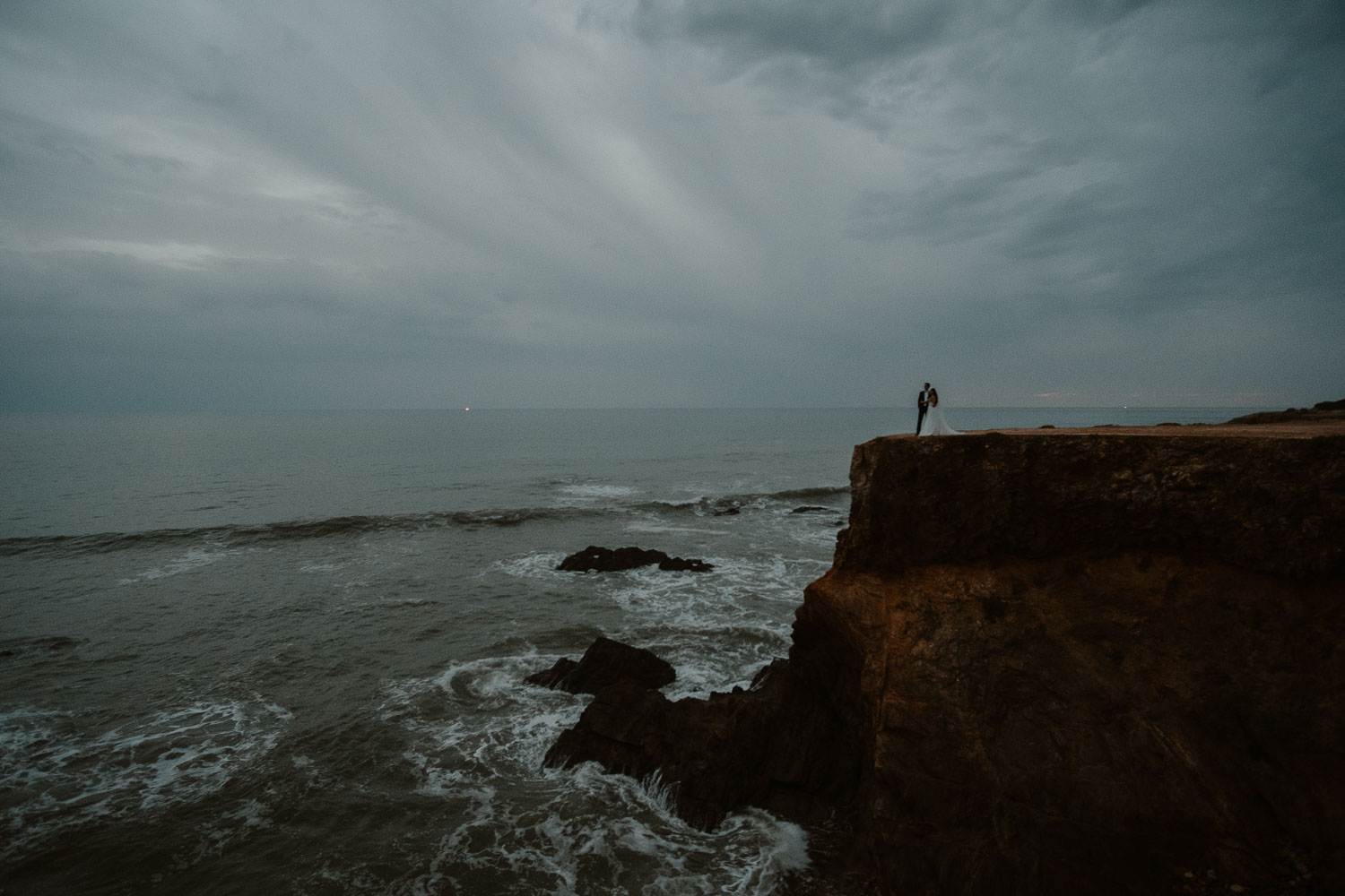 Photographie spectaculaire d’un couple de mariés à la tombée du jour