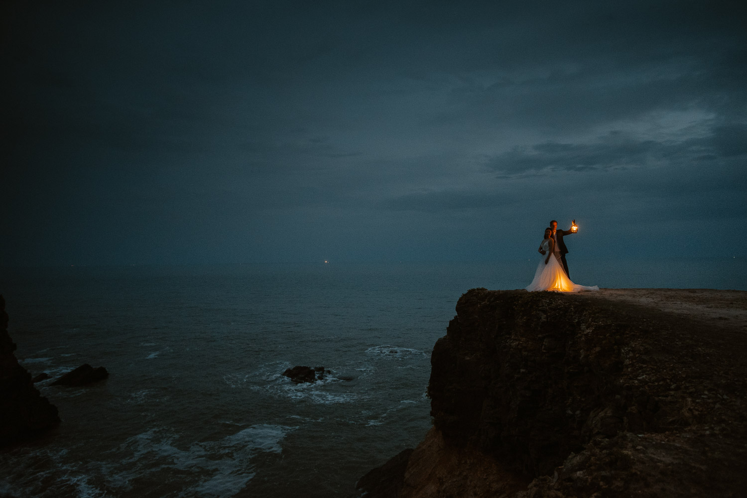 Photographie spectaculaire d’un couple de mariés à la tombée du jour