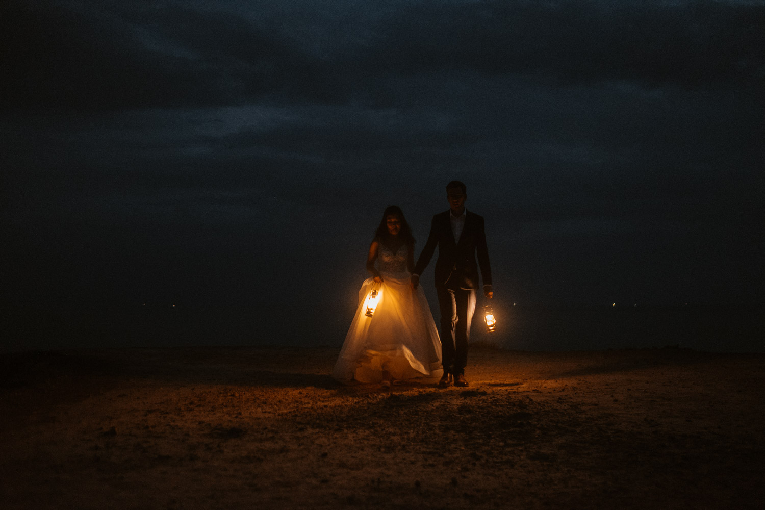 Photographie nocturne poétique d’un couple de mariés à la tombée du jour