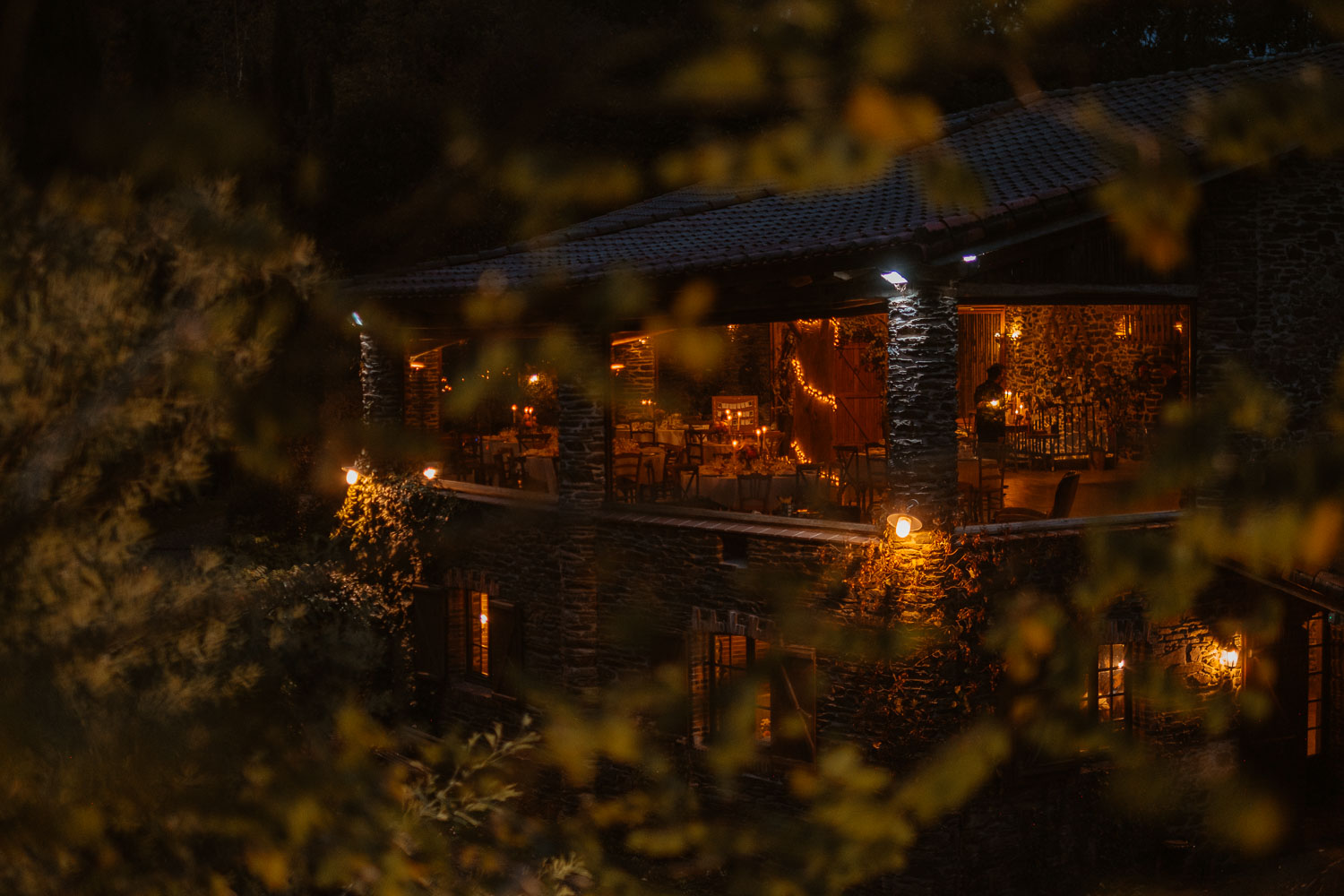Vue de l'extérieur d'une salle de mariage en automne à la tombée de la nuit