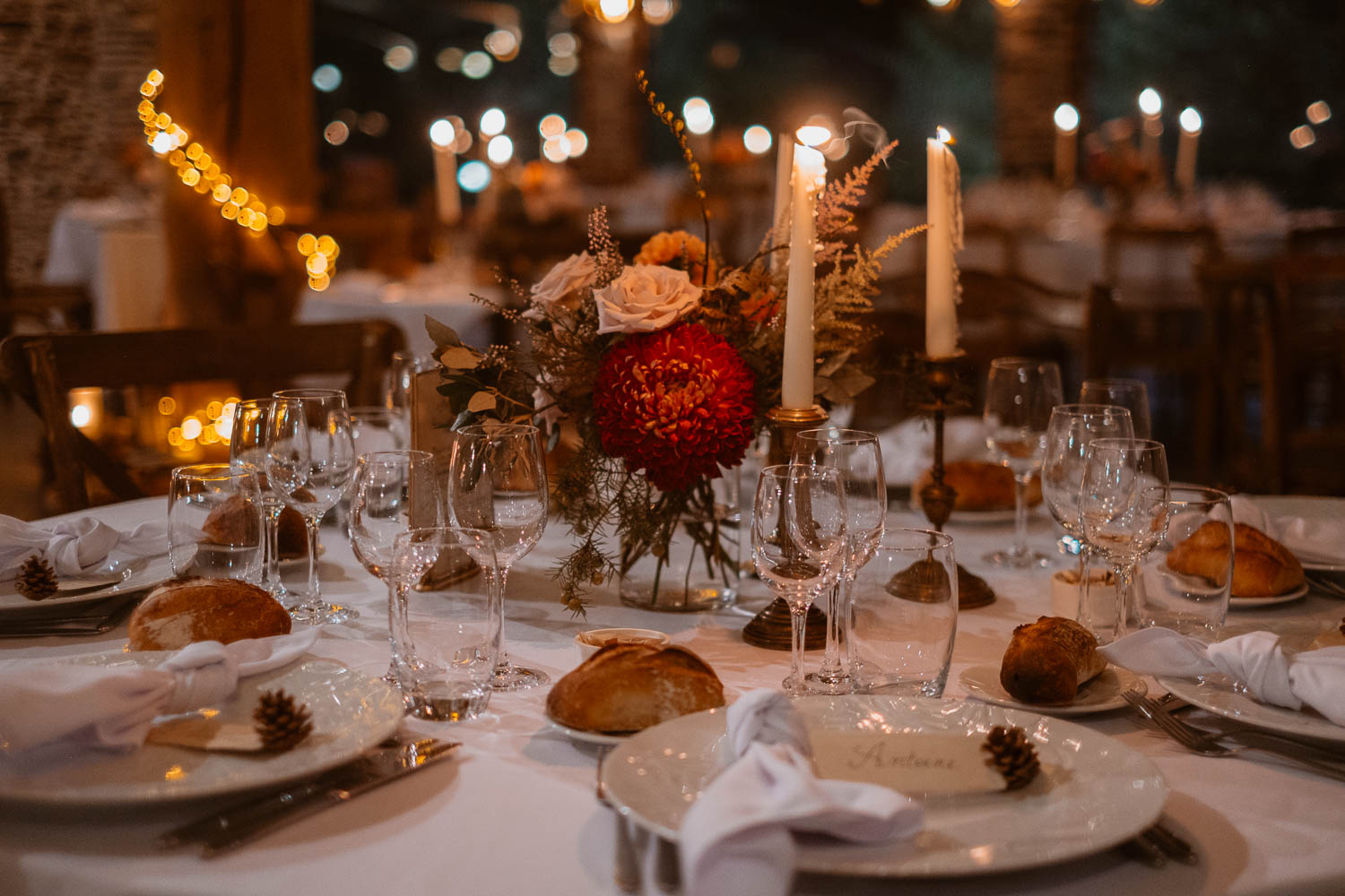 Photographie d'une salle de mariage en automne à la tombée de la nuit à la lumière des bougies